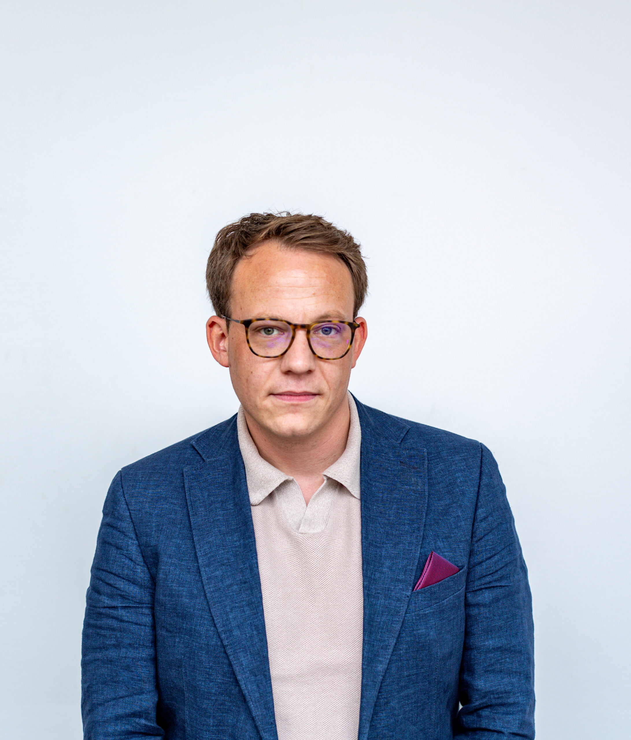 Simon Gläve im Sakko mit direktem Blick in die Kamera