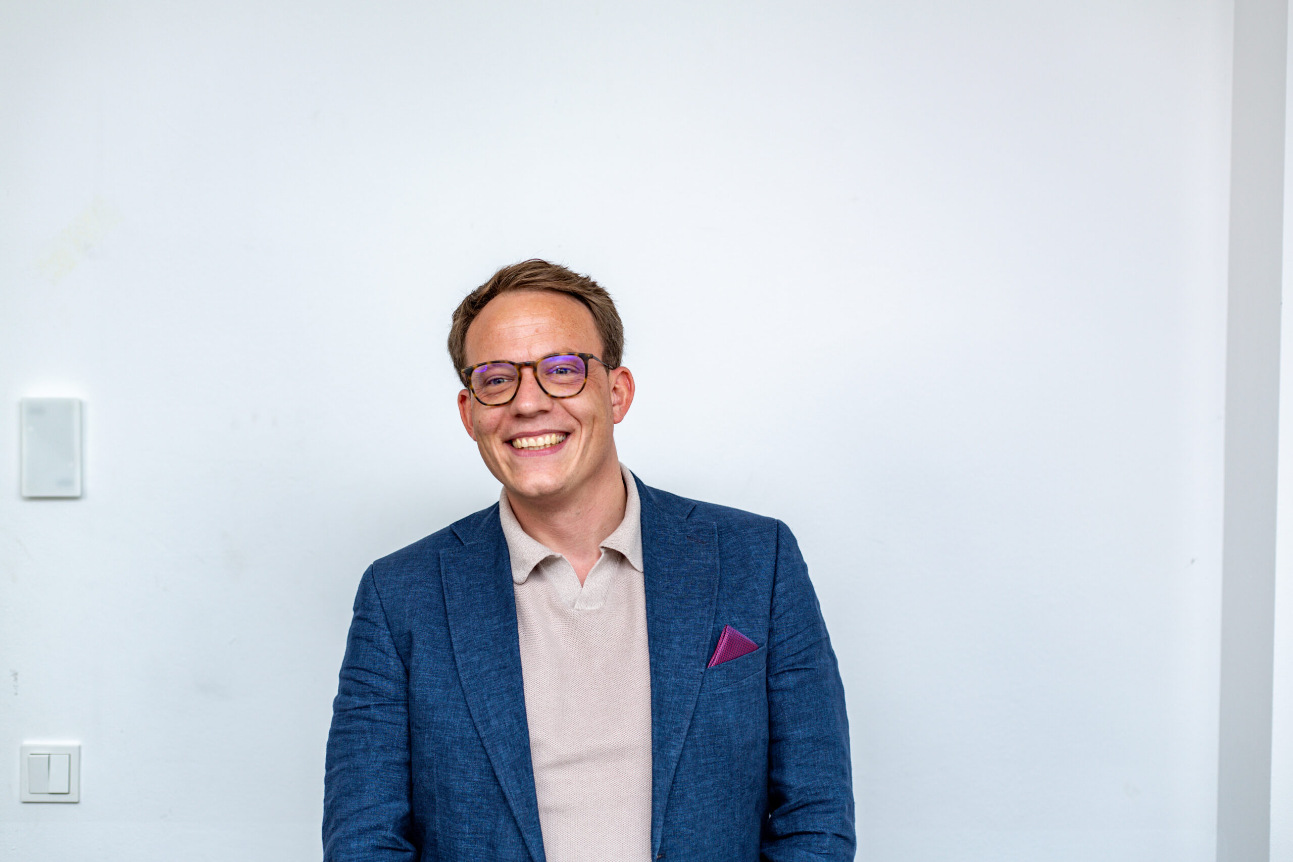 Simon Gläve lacht im Sakko