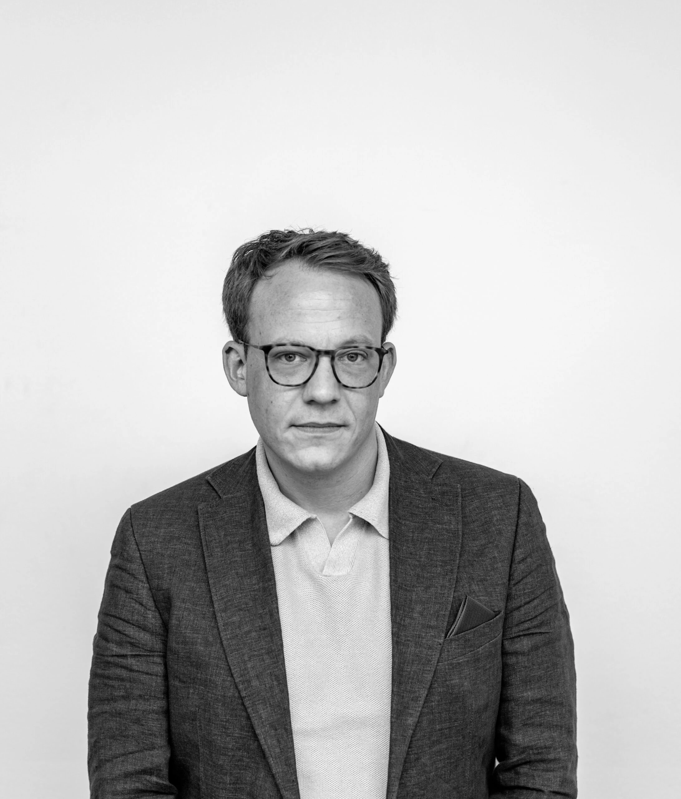 Simon Gläve im Sakko mit direktem Blick in die Kamera